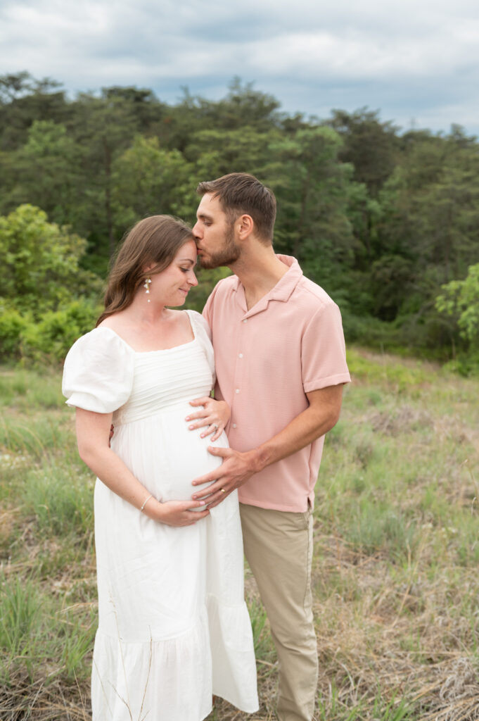 Maternity photographer in Baltimore capturing a glowing mom holding her belly with a maternity and newborn photography.