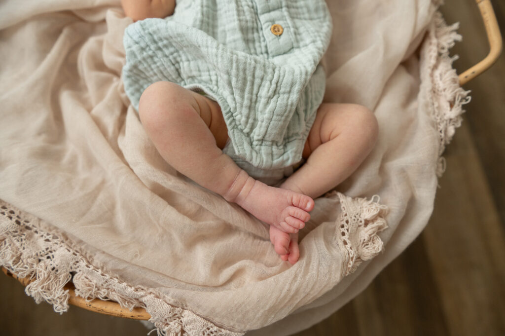 Newborn wrapped in neutral cream tones during a calm studio shoot with maternity and newborn photography services.