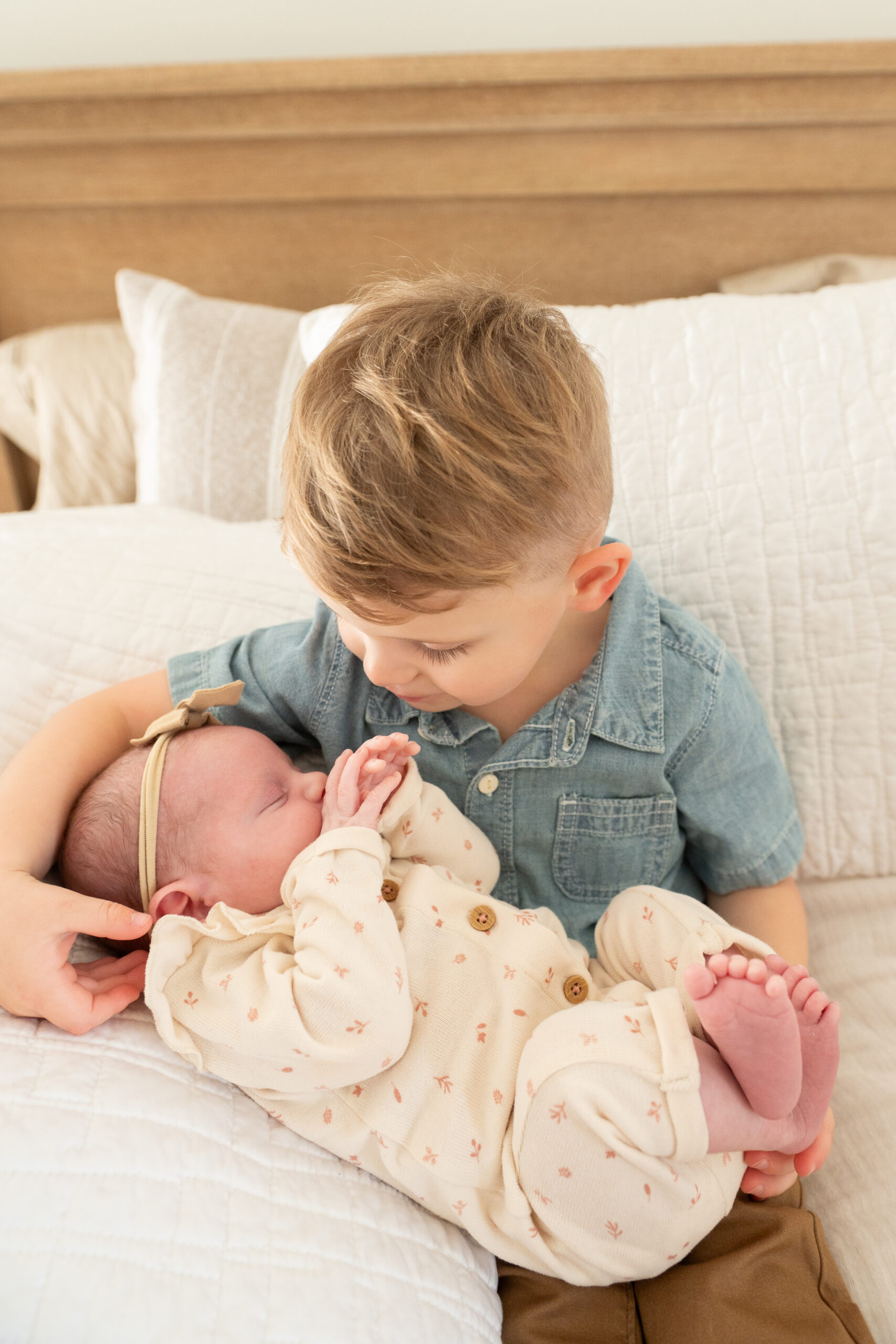 Sibling gently meeting the new baby during a newborn family photoshoot