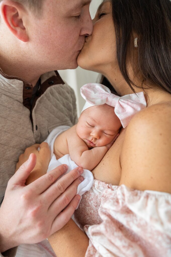 Mom holding newborn baby against her chest during Baltimore lifestyle newborn photography session.